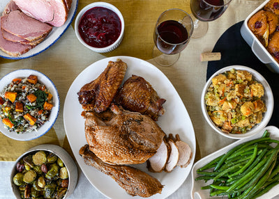 A Thanksgiving table set with a platter of turkey and sides