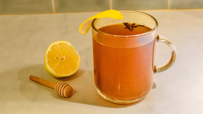 Hot toddy in a clear mug with lemon zest