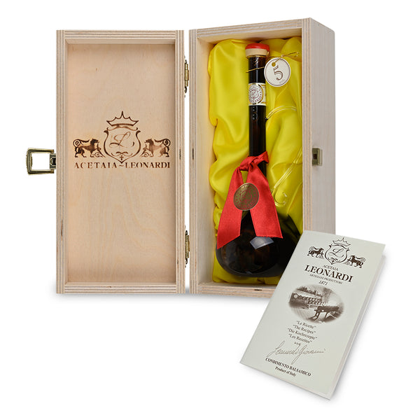 Open wooden fabric-lined gift box revealing glass bottle of Leonardi 5 year-aged balsamic vinegar