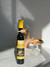 200 ml bottle of Agrumato Bergamot Olive Oil in front of a cake stand holding dried citrus slices