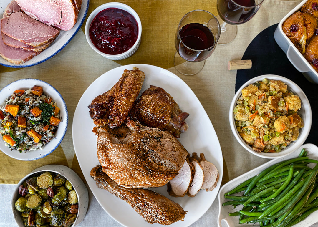 A Thanksgiving table set with a platter of turkey and sides