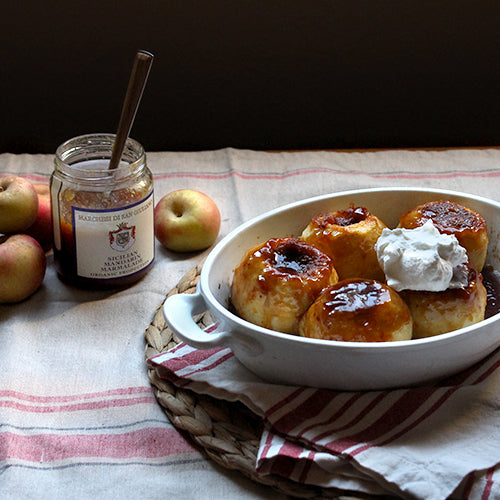 Sicilian Baked Apples in a white bowl with an open jar of marmalade