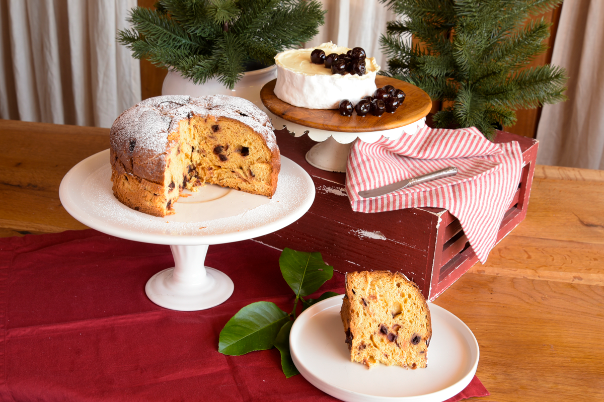Open panettone on cake stand cheese and candied cherries