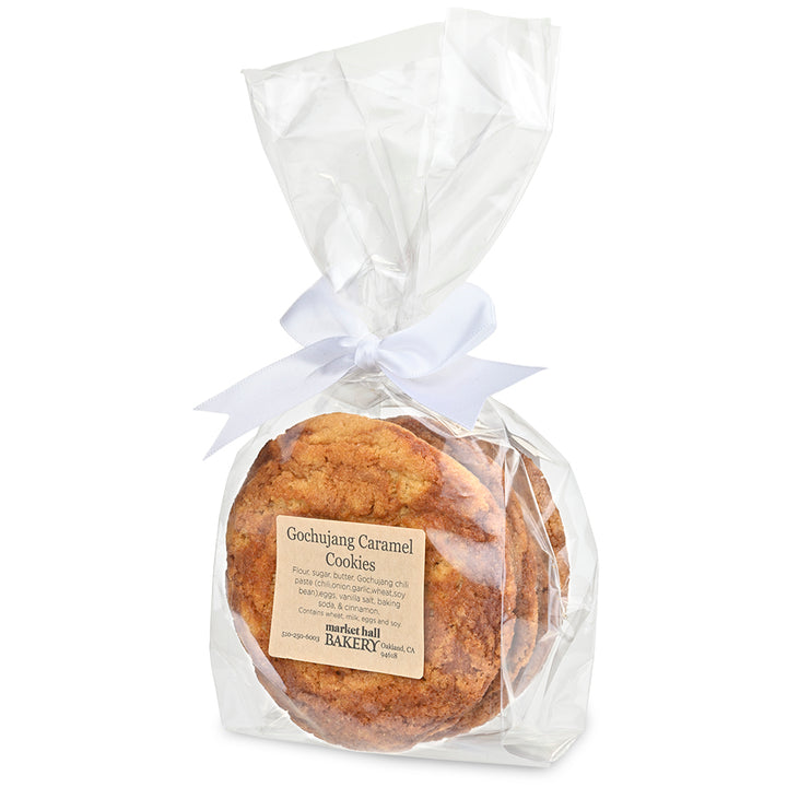 A package of gourmet cookies from Market Bell Bakery, featuring two round Chujang caramel cookies sealed in a clear cellophane bag with a white ribbon, on a white background.