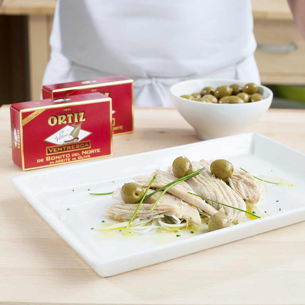 Ortiz ventresca on a plate with olives and chives