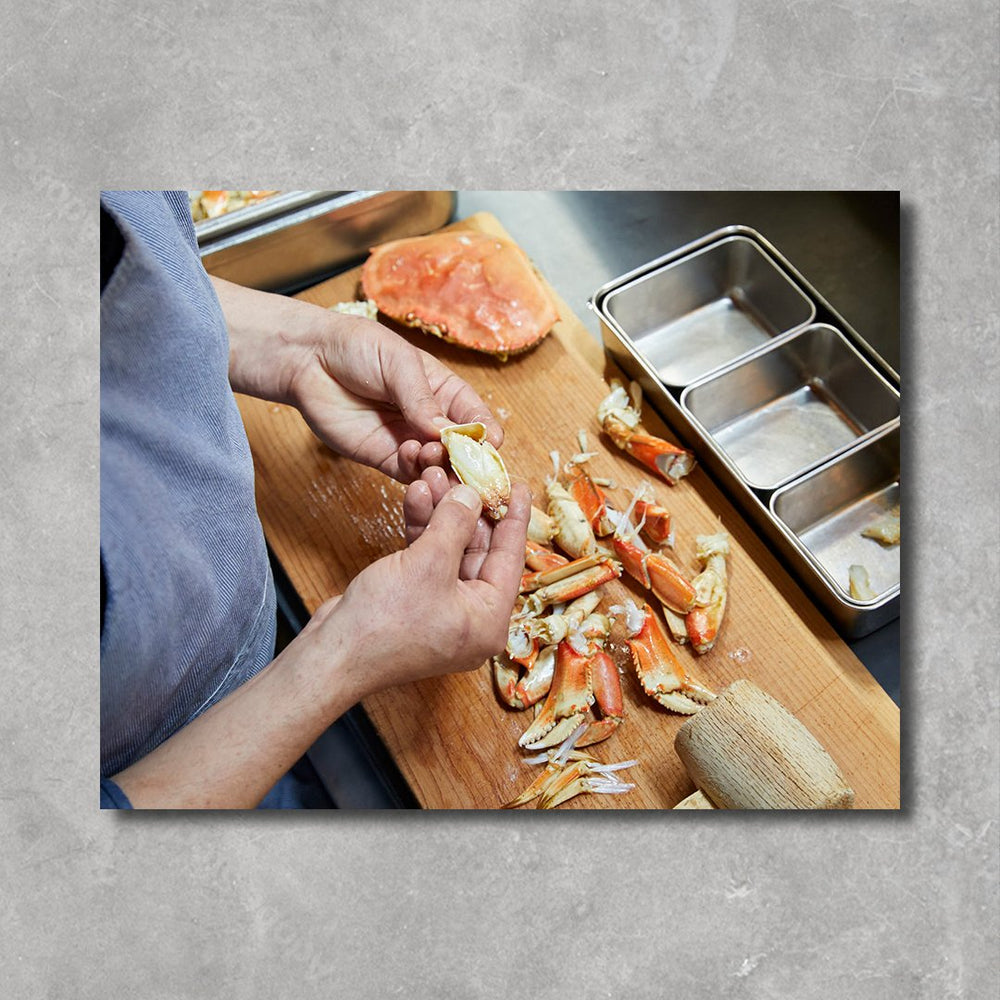 Inside the book: an image of hands cracking open a crab