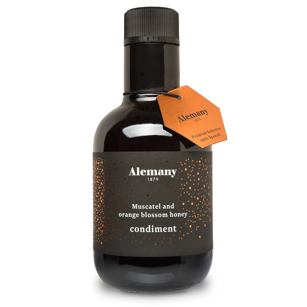 Black bottle of Alemany muscatel and orange blossom honey condiment with an orange tag on a white background