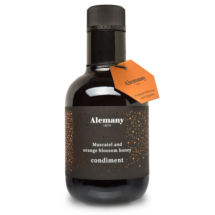 Black bottle of Alemany muscatel and orange blossom honey condiment with an orange tag on a white background
