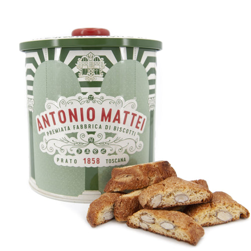 Pieces of almond biscotti in front a red and green gift tin