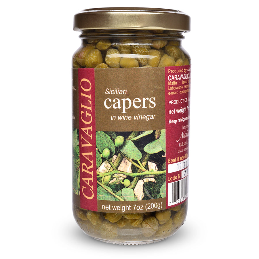 Jar of Sicilian capers in wine vinegar with a visible label on a white background