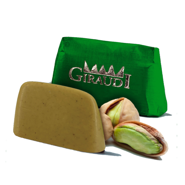 Giraudi pistachio chocolate with green foil next to cracked open pistachio