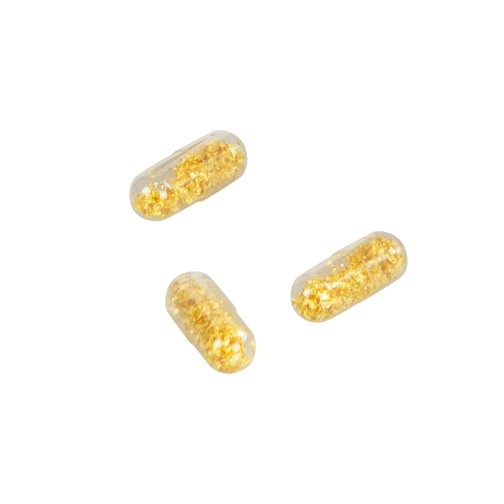 Gold-filled capsules on a white background