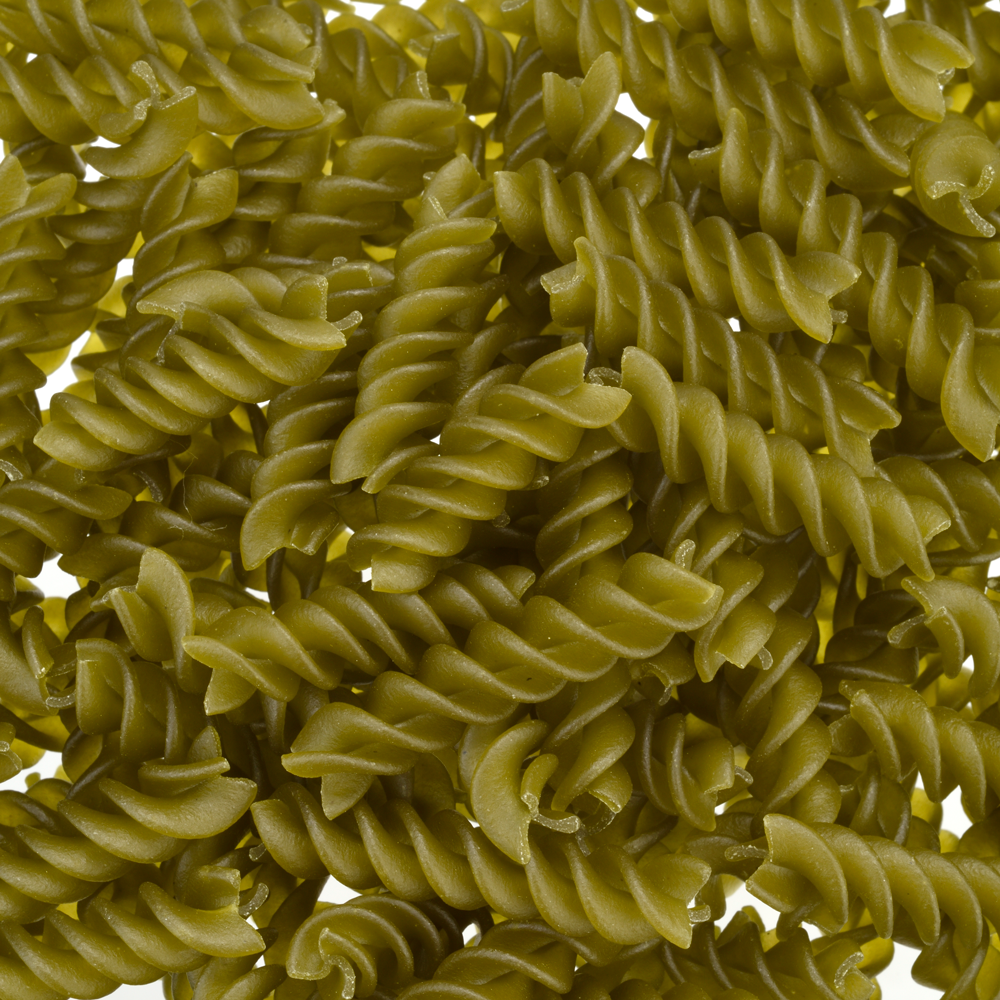 Close-up of green fusilli pasta on a white background