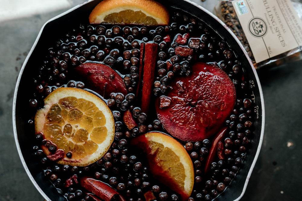 A pot of mulled wine with orange slices, apple and India Tree's Mulling Spice Blend