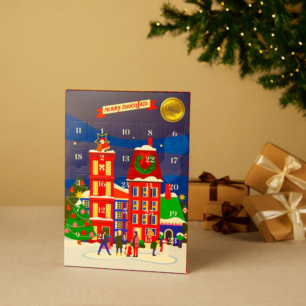 Chocolate advent calendar with festive design on a beige surface with Christmas decorations.