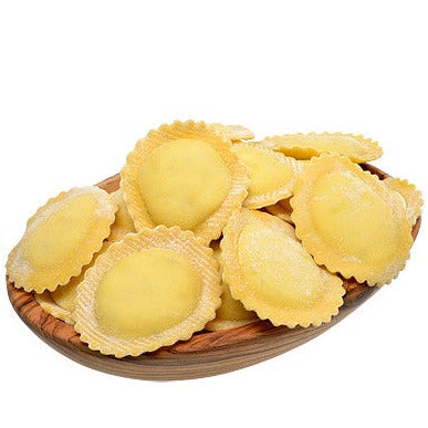 Fresh goat cheese and pear ravioli on a wood board
