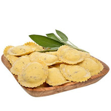 Fresh ravioli with sage and butternut squash on a wood board